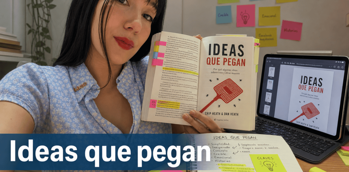 Mujer mostrando libro 'Ideas que Pegan' en escritorio.