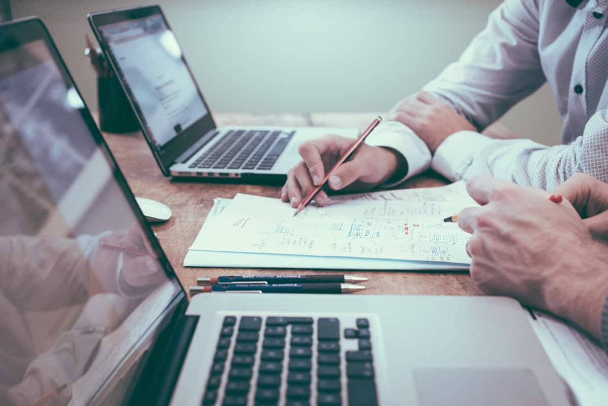 Reunión de trabajo con portátiles y documentos.