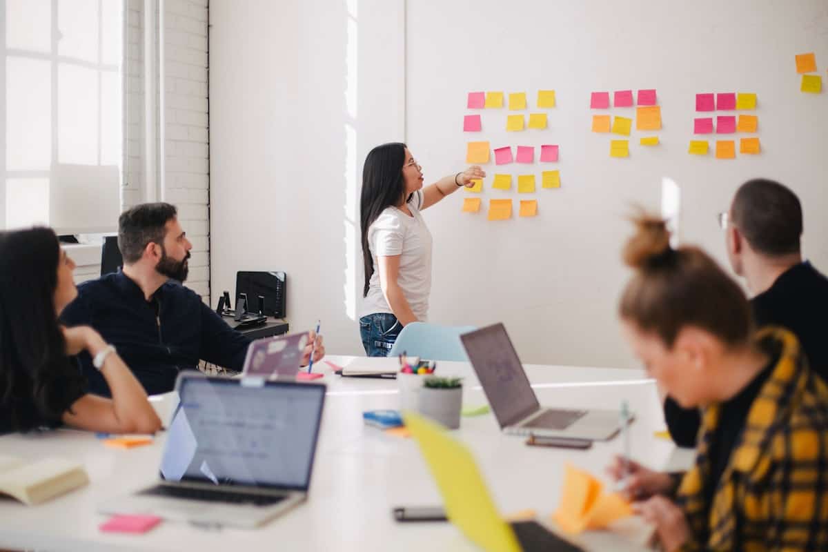 Reunión de equipo con planificación en pizarra.