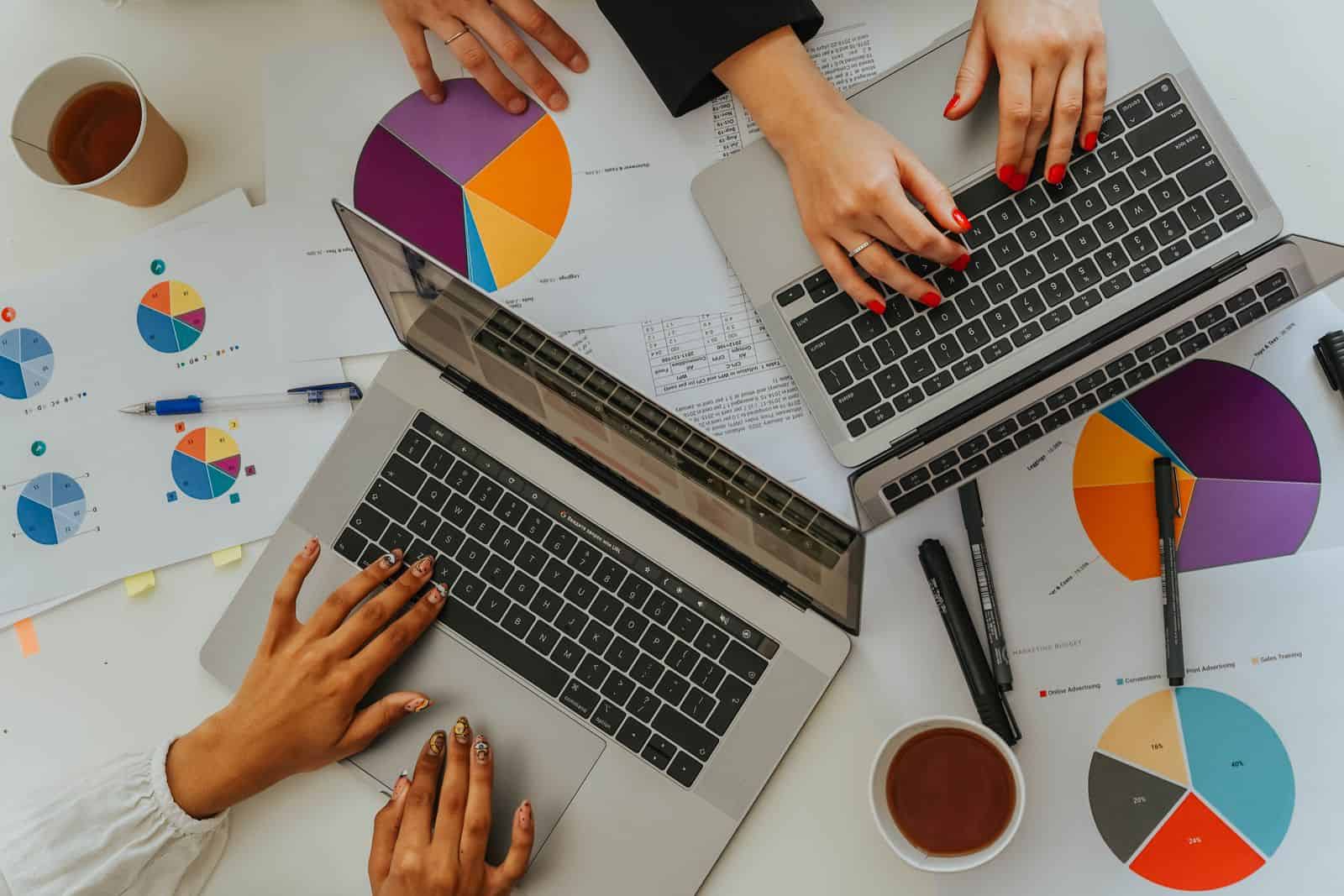 Automatización de procesos administrativos: dos profesionales analizan datos en portátiles con gráficos
